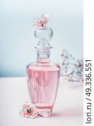 Floral Perfume bottle with flowers, front view. Perfumery, cosmetics, botanical fragrance concept. Pastel color. Beauty concept. Стоковое фото, агентство Ingram Publishing / Фотобанк Лори