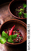 Different kinds of peppercorns.. Black,red and white pepper in clay bowl.Set of different peppers. Стоковое фото, агентство Ingram Publishing / Фотобанк Лори