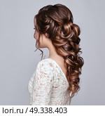 Brunette Woman with Long and shiny Curly Hair. Beautiful Model Lady with Curly Hairstyle. Care and Beauty Hair products. Care and Beauty of Hair. Стоковое фото, агентство Ingram Publishing / Фотобанк Лори