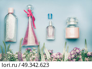 Natural cosmetic products. Jars and bottles with tonic , mist, perfume,cream ,tonic and micellar water on herbal leaves and wild flowers background, copy space for your text or branding , top view. Стоковое фото, агентство Ingram Publishing / Фотобанк Лори