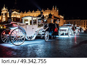 The old square of the night krakow with luminous horse-drawn carriages. Стоковое фото, агентство Ingram Publishing / Фотобанк Лори