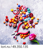 Beads and tulip. Beads, colorful beads for needlework and tulip.Fashion beads. Стоковое фото, агентство Ingram Publishing / Фотобанк Лори
