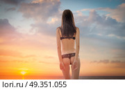 woman in a swimsuit is standing ass at sunset. woman in a swimsuit is standing ass. Стоковое фото, агентство Ingram Publishing / Фотобанк Лори