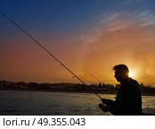 Angler with spinning rod fishing in Mediterranean. Angler with spinning rod fishing in Mediterranean sea of Javea Spain. Стоковое фото, агентство Ingram Publishing / Фотобанк Лори