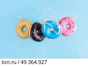 flying doughnuts on blue. flying doughnuts chain on blue background. Стоковое фото, агентство Ingram Publishing / Фотобанк Лори
