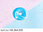flying doughnuts on blue. one sweet doughnut with sprinkles on blue and pink abstract background with copy space. Стоковое фото, агентство Ingram Publishing / Фотобанк Лори