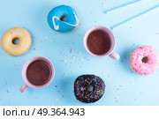 flying doughnuts on blue. Two sweet doughnuts with cacao on blue background with copy space, top view scene. Стоковое фото, агентство Ingram Publishing / Фотобанк Лори