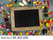 Colorful halloween candies on stone. Trick and treat sweets - colorful halloween candies on stone with copy space, copy on blackboard. Стоковое фото, агентство Ingram Publishing / Фотобанк Лори