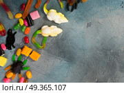 Colorful halloween candies on stone. Trick and treat concept - colorful halloween candies border with mouses and spiders on stone with copy space. Стоковое фото, агентство Ingram Publishing / Фотобанк Лори