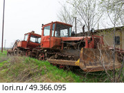 Старый сельскохозяйственный гусеничный трактор ДТ-75, бульдозер, в ожидании ремонта. Городище, Волгоградская область, Россия. (2023 год). Редакционное фото, фотограф Андрей Цыганков / Фотобанк Лори