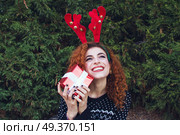 Young woman holding a christmas gift . Стоковое фото, агентство Ingram Publishing / Фотобанк Лори