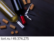 Bottles of red and white wine with corks on wooden table. Glass of red wine. Стоковое фото, агентство Ingram Publishing / Фотобанк Лори