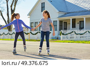 Teen girls group rolling skate in the street outdoor. Стоковое фото, агентство Ingram Publishing / Фотобанк Лори