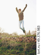 Young woman jumping outdoors . Стоковое фото, агентство Ingram Publishing / Фотобанк Лори