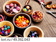 Variety of shapes and colors beads to make a bead necklace.Handcraft. Colorful beads in wooden bowls. Стоковое фото, агентство Ingram Publishing / Фотобанк Лори