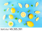 Fresh lemon citrus fruits slices with mint leaves falt lay pattern on blue bakground. Fresh lemon fruits. Стоковое фото, агентство Ingram Publishing / Фотобанк Лори