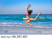 acrobatic gymnastics bikini girl in a beach blue shore at summer. Стоковое фото, агентство Ingram Publishing / Фотобанк Лори
