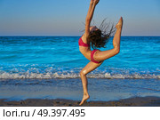 acrobatic gymnastics bikini girl in a beach blue shore at summer. Стоковое фото, агентство Ingram Publishing / Фотобанк Лори