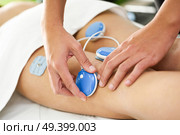 Physiotherapist applying electro stimulation in physical therapy to a young woman. Medical check at the leg in a physiotherapy center. Стоковое фото, агентство Ingram Publishing / Фотобанк Лори