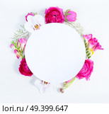 Flowers composition. Round frame made of dried eucaliptus leaves and flowers on white background. Flat lay, top view, copy space on white paper. Flowers flat lay composition. Стоковое фото, агентство Ingram Publishing / Фотобанк Лори