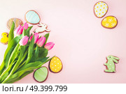 Eater handmade cookies with tulip flowers bouquet on pink background, retro toned. Easter scene with colored eggs. Стоковое фото, агентство Ingram Publishing / Фотобанк Лори