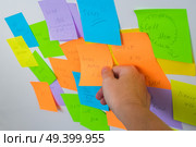 To do list - multicolored task notes with hadnd choosing one close up. To do lists. Стоковое фото, агентство Ingram Publishing / Фотобанк Лори