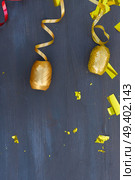 Carnaval festive golden curling paper with copy space on dark wooden background. Carnaval decorations on dark wooden background. Стоковое фото, агентство Ingram Publishing / Фотобанк Лори