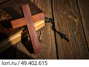 Christian cross on wood bible and rosary beads over wooden vintage background. Стоковое фото, агентство Ingram Publishing / Фотобанк Лори