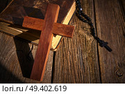 Christian cross on wood bible and rosary beads over wooden vintage background. Стоковое фото, агентство Ingram Publishing / Фотобанк Лори