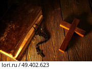 Christian cross on wood bible and rosary beads over wooden vintage background. Стоковое фото, агентство Ingram Publishing / Фотобанк Лори