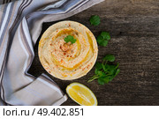 Plate of hummus with lemon on wooden table with copy space, top view. Plate of hummus. Стоковое фото, агентство Ingram Publishing / Фотобанк Лори