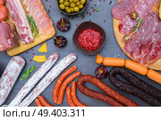 spanish tapas with pancetta, salami, chorizo, lomo, jamon with red hol salsa sause and olives, picnic table, top view. Picnic table with spanish sausage tapas. Стоковое фото, агентство Ingram Publishing / Фотобанк Лори
