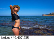 Bikini girl in summer Mediterranean beach having fun with beach hat. Стоковое фото, агентство Ingram Publishing / Фотобанк Лори