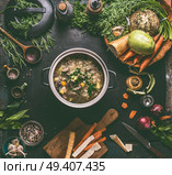 Beef and cabbage soup or stew in cast iron cooking pot on dark background with low carb vegetables, spices ingredients and wooden spoon, top view. Healthy clean low-calorie food and eating concept. Стоковое фото, агентство Ingram Publishing / Фотобанк Лори