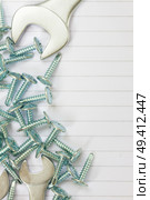 disassembled screws and wrenches on white ruled paper background with yellow tape an copy space. Стоковое фото, агентство Ingram Publishing / Фотобанк Лори