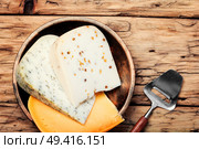 Assortment of cheeses on a wooden table. Delicious cheese on the table. Стоковое фото, агентство Ingram Publishing / Фотобанк Лори