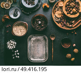 Preparation of homemade vegan chocolate truffle pralines with dried fruits and nuts mix, ingredients on dark background, top view. Healthy sweets. Energy vegan balls with dates, cocoa and almond. Стоковое фото, агентство Ingram Publishing / Фотобанк Лори