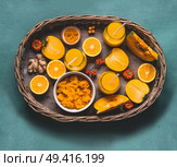 Healthy pumpkin smoothie in glasses with  orange color ingredients : persimmon , orange fruits, ginger and turmeric powder in wooden tray, top view. Immune boosting detox beverage for cold season. Стоковое фото, агентство Ingram Publishing / Фотобанк Лори