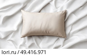 Soft beige pillow resting on smooth, elegant white fabric background. Мягкая бежевая подушка лежит на гладком, элегантном фоне из белой ткани. Стоковое AI-изображение, AI-художник Katsiaryna Repich / Фотобанк Лори