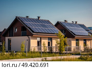 Two residential houses with solar panels installed on their roofs to harness solar energy for powering the homes. Стоковое AI-изображение, AI-художник Данила Большаков / Фотобанк Лори