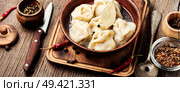 Traditional Russian dish pelmeni.Meat dumplings on wooden rustic background. Dumplings with meat. Стоковое фото, агентство Ingram Publishing / Фотобанк Лори