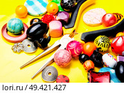 Jewelry making and beading process.Colored beads on yellow background. Beads on yellow background. Стоковое фото, агентство Ingram Publishing / Фотобанк Лори