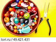Jewelry making and beading process.Colored beads on yellow background. Beads on yellow background. Стоковое фото, агентство Ingram Publishing / Фотобанк Лори