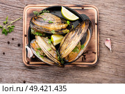 Shellfish mussels in frying pan with lemon.Clams in the shells. Delicious seafood mussels. Стоковое фото, агентство Ingram Publishing / Фотобанк Лори