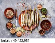 Smoked fish with spices.Cold smoked fish.Smoked capelin. Appetizing smoked fish. Стоковое фото, агентство Ingram Publishing / Фотобанк Лори