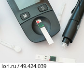 Набор для измерения уровня глюкозы (сахара) в крови: глюкометр, тест-полоска, ланцет. Стоковое фото, фотограф Snezka / Фотобанк Лори