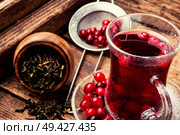 Cranberry tea in a glass cup on wooden table. Berry tea on wooden table. Стоковое фото, агентство Ingram Publishing / Фотобанк Лори