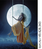Elegant woman over large moon background. Стоковое фото, агентство Ingram Publishing / Фотобанк Лори
