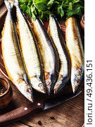 Appetizing smoked fish on kitchen board.Smoked saury.Smoked fish with spices. Smoked sanma or pacific saury. Стоковое фото, агентство Ingram Publishing / Фотобанк Лори