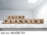 Event planning sign on a wooden desk in an office with a blurry grey background. Стоковое фото, агентство Ingram Publishing / Фотобанк Лори
